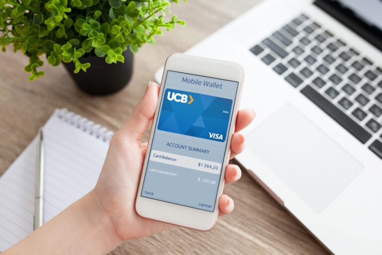 A customer looking at UCB Mobile Wallet on phone.